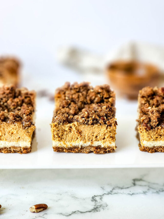 Pumpkin Cheesecake Bars Sliced and Sitting on White Serving Plate