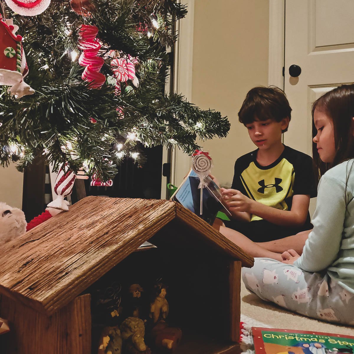 Children Reading Together by the Christmas Tree