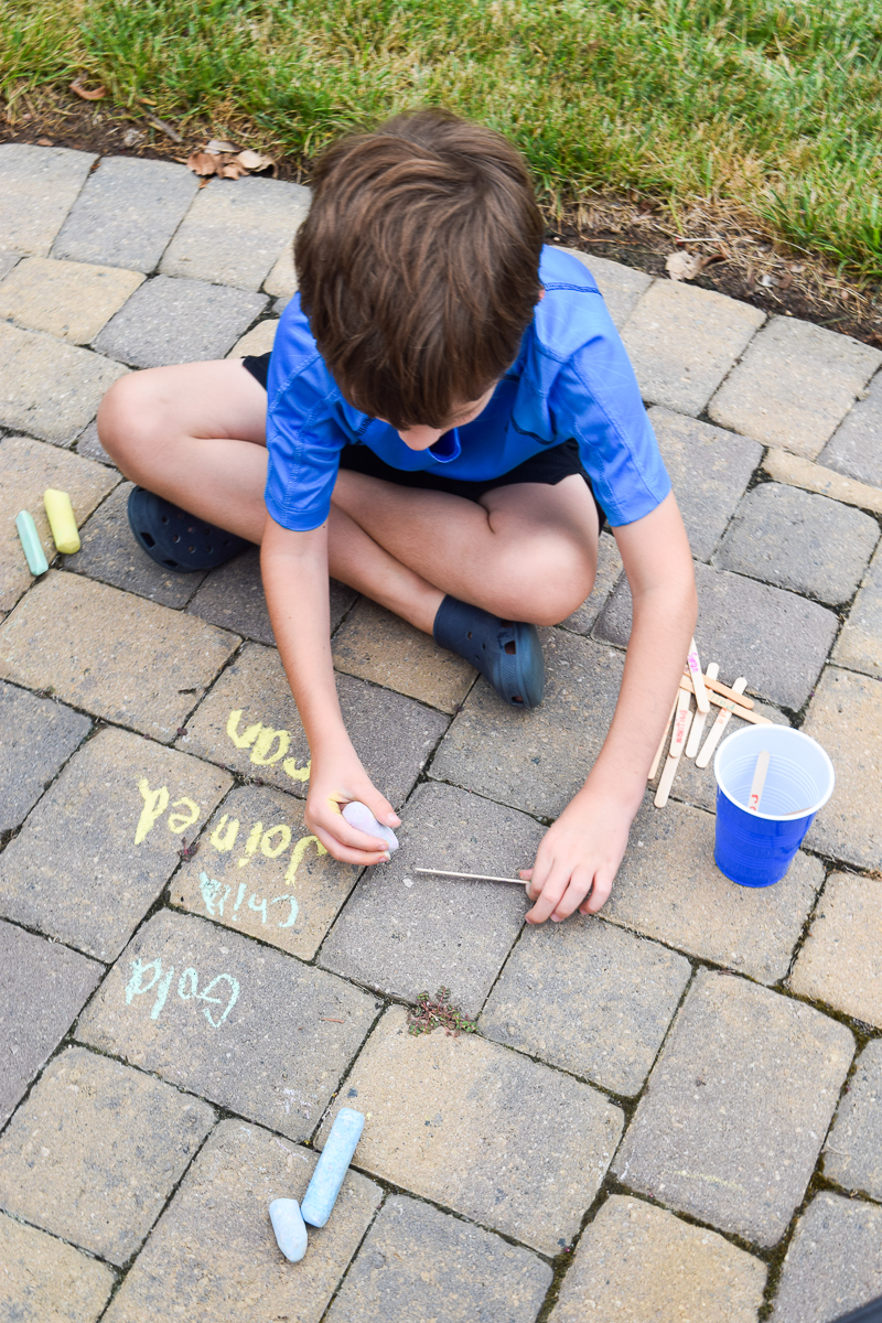 Elementary Student Writing on the Ground with Sidewalk Chalk