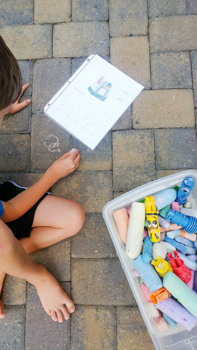 Boy Practicing Cursive Using Sidewalk Chalk to Write