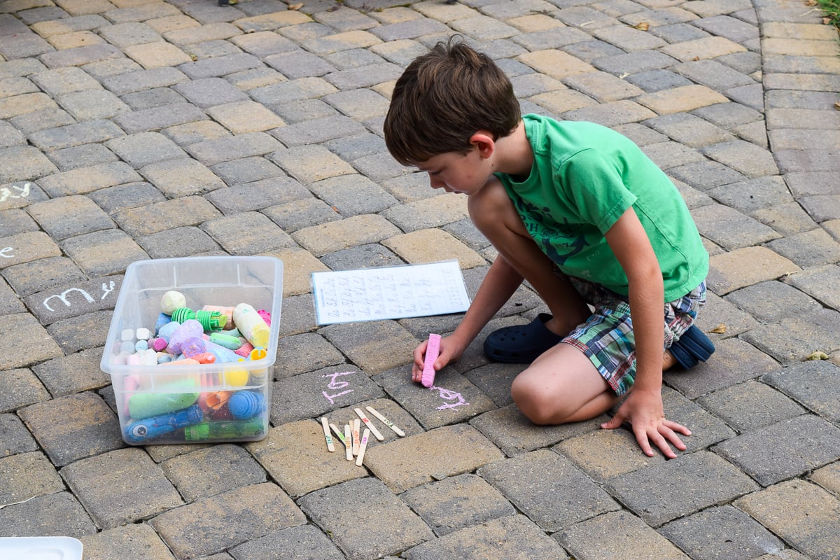 Boy Writing Spelling Words with Sidewalk Chalk