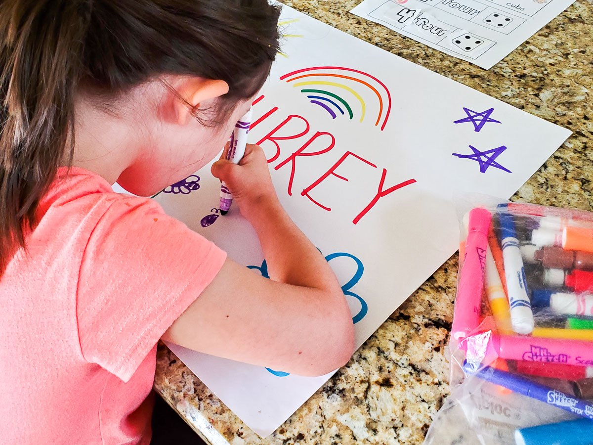 Young Girl Decorating a Poster with Her Name on It