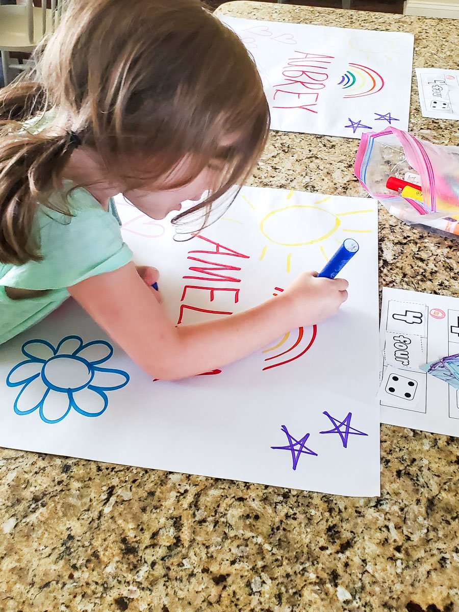 Young Girl Decorating a Poster with Her Name on It