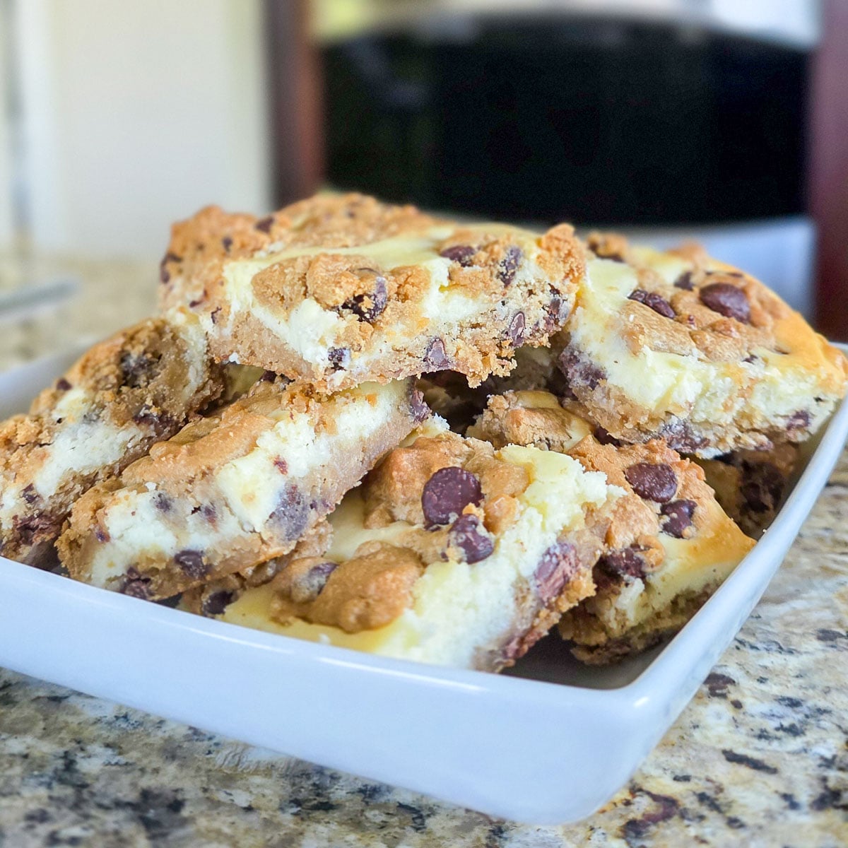 Chocolate Chip Cheesecake Bars on White Serving Plate