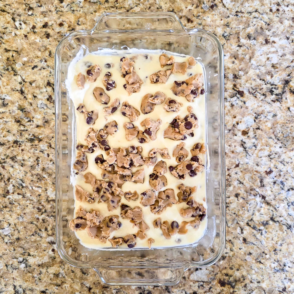 Unbaked Chocolate Chip Cookie Bars in a Glass Baking Dish
