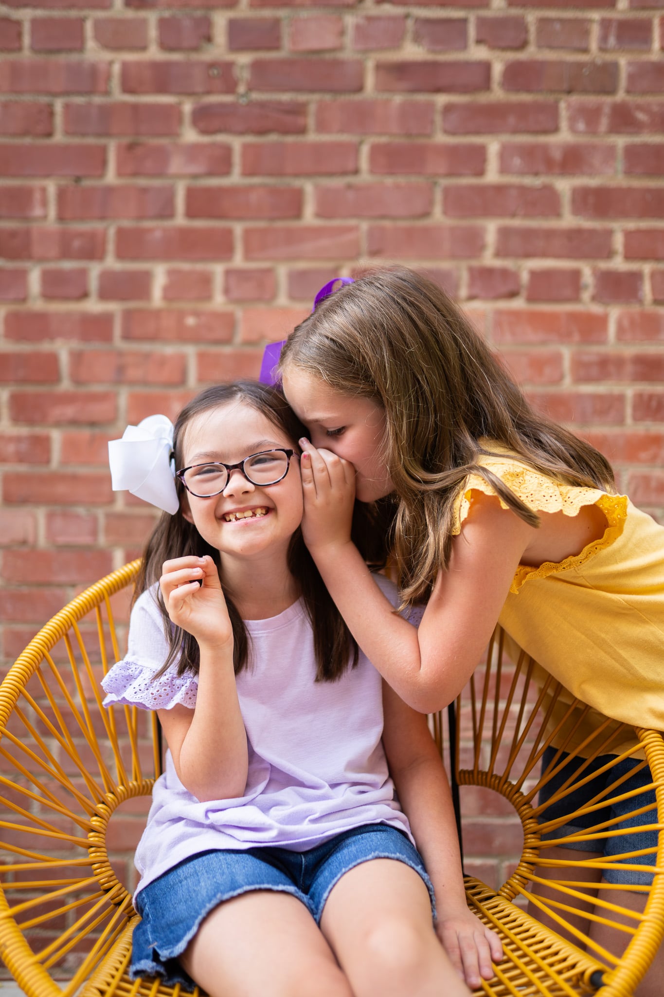 Girls Posing for Photo in Front of Brick Wall