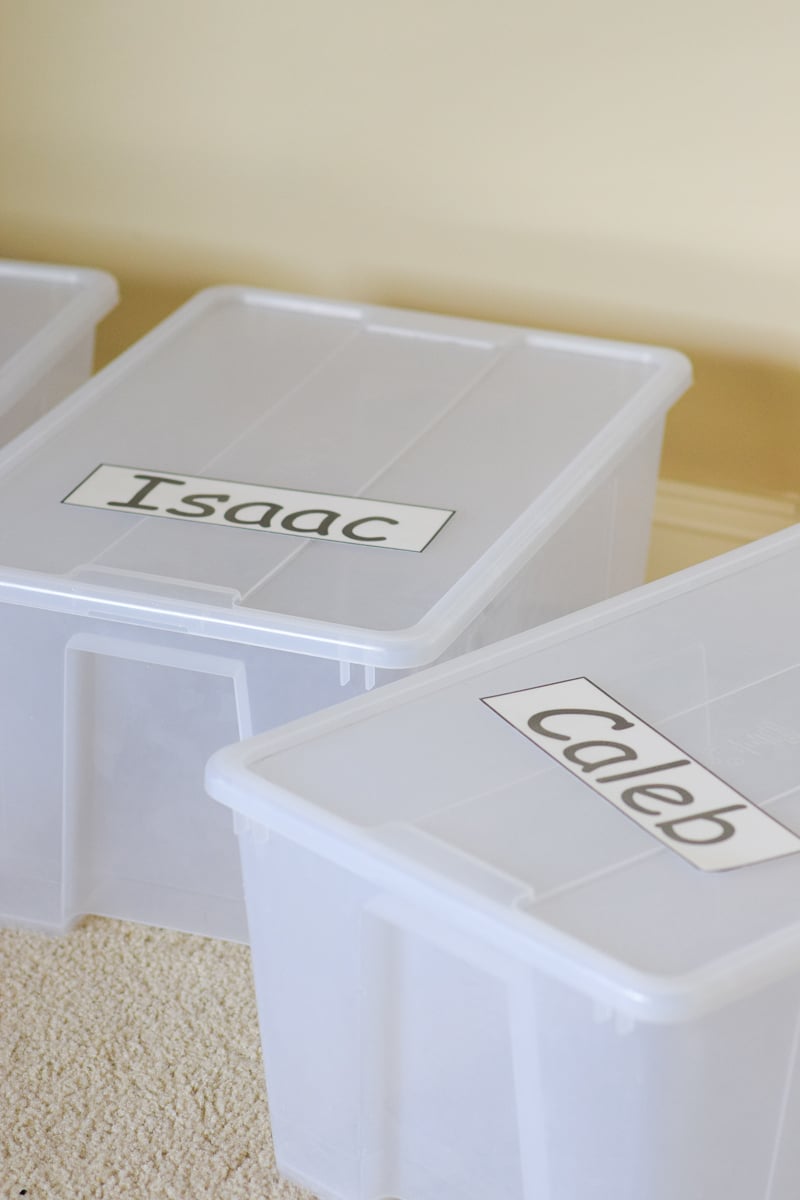 Two Plastic Storage Bins with Names on Them